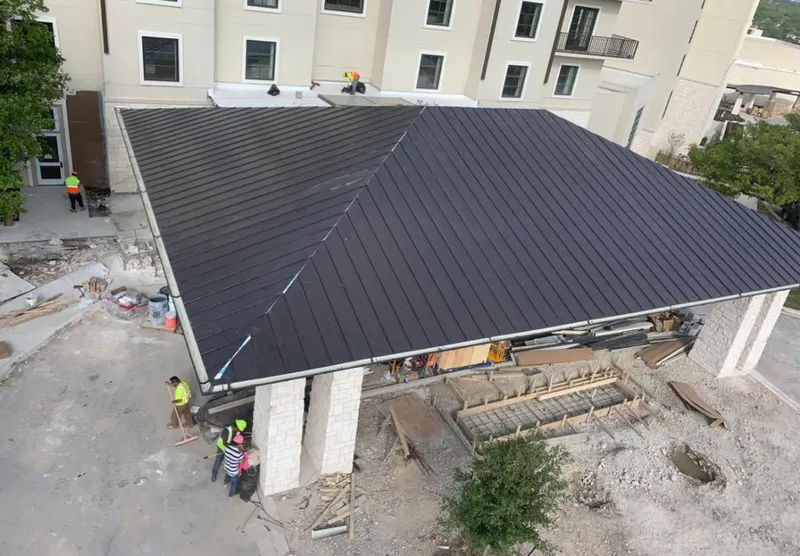 Metal roofing installation team working on a commercial building in Clovis